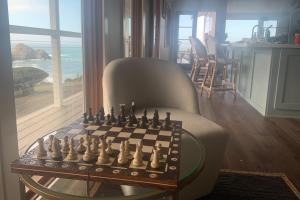ein Schachbrett auf einem Glastisch in einem Wohnzimmer in der Unterkunft Panoramic Ocean View Home in Elk with Beach Access in Elk + 35 Fotos