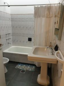 a bathroom with a tub and a toilet and a sink at FourDoor in Guaymallen