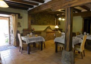una sala da pranzo con tavoli, sedie e camino di La Casa De Las Arcas a Vada