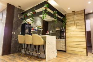 uma cozinha com um bar com bancos e um balcão em SUITS HOTEl تشغيل مؤسسه سويت لتشغيل الفنادق em Jidá