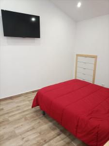 una camera con letto rosso e TV a schermo piatto di Jacuzzi Barcala a Valga