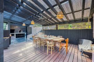 une salle à manger avec une table et des chaises sur une terrasse dans l'établissement La Maison du Lac - Passerelles de Monteynard, à Lavars