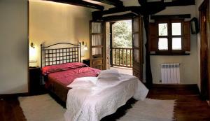 a bedroom with a bed and a large window at La Casa De Las Arcas in Vada