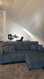 uma sala de estar com um sofá azul e uma mesa em Ferienhaus Fee em Erbach