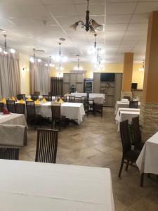 a dining room with white tables and chairs at H&T Pension-Restaurant in Jigodinu