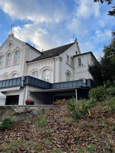 een groot wit gebouw bovenop een heuvel bij Boardinghouse am Herforder Tor für 8 Personen auf 160 m2 in Bad Salzuflen