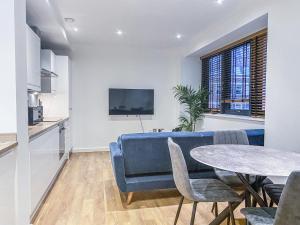 - un salon avec un canapé bleu et une table dans l'établissement Cathedral View Apartments by Elegance Living, à Peterborough