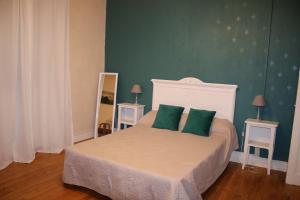 - une chambre avec un lit et 2 oreillers verts dans l'établissement Maison Hormidas, à Crouseilles