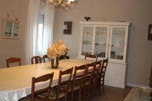 a dining room table with chairs and a vase with flowers at Maison Hormidas in Crouseilles
