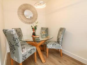 a dining room with a glass table and two chairs at Harley's Hideaway in Appledore