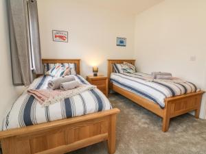 two beds sitting next to each other in a bedroom at Harley's Hideaway in Appledore
