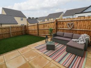 a backyard with a couch and a fence at Harley's Hideaway in Appledore