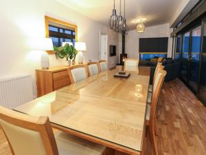 a dining room and living room with a table and chairs at 2 Strathtay Lodges in Aberfeldy
