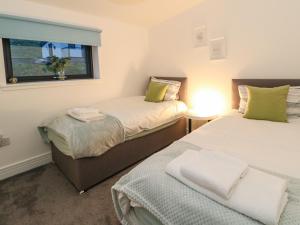 2 Betten in einem kleinen Zimmer mit Fenster in der Unterkunft 2 Strathtay Lodges in Aberfeldy
