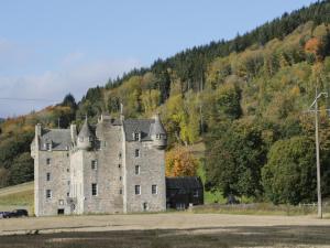 an old castle sitting in the middle of a field at 2 Strathtay Lodges in Aberfeldy