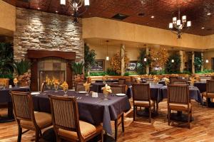a dining room with tables and chairs and a fireplace at Maverick Hotel and Casino by Red Lion Hotels in Elko