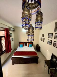 a bedroom with a bed with chandeliers above it at Supyar Mahal in Jaipur