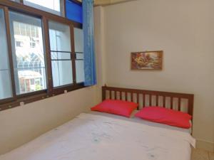 1 dormitorio con 1 cama con 2 almohadas rojas en ห้องพักสุขสบายวังหลัง en Bangkok