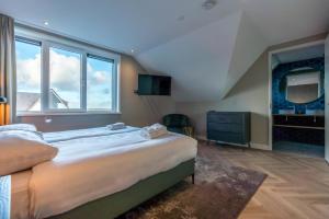 a bedroom with a large bed and a large window at Vakantiewoning De Princenhof in De Cocksdorp