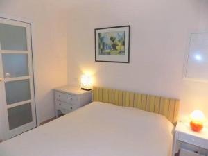 1 dormitorio con 1 cama blanca grande y vestidor en Saint Palais sur Mer - PETITE MAISON - dans un CADRE PRIVILIGIÉ au CALME en Saint-Palais-sur-Mer