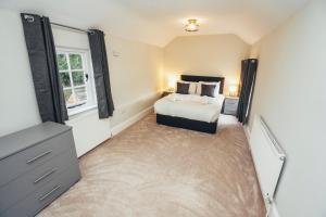 a bedroom with a bed and a dresser at Cottages in Derbyshire, King Street Cottage in Duffield