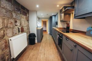 a kitchen with a stone wall and a counter at Cottages in Derbyshire, King Street Cottage in Duffield