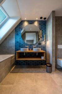 a bathroom with two sinks and a mirror at Vakantiewoning De Princenhof in De Cocksdorp