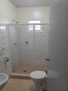 a bathroom with a shower and a toilet and a sink at La Maison Hebridaise in Luganville