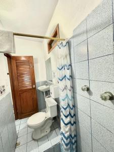 a bathroom with a toilet and a shower at Hostal Gardner in Puerto Ayora