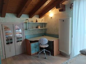 Habitación pequeña con escritorio y silla. en Villetta di montagna, en Foza