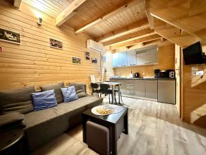 a living room with a couch and a kitchen at Domki na Jurze in Kroczyce