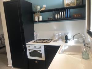 a kitchen with a stove top oven next to a sink at T&L Apartments Germasogia in Limassol