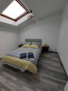 een slaapkamer met een bed in een kamer met een raam bij Gîte La p'tite Maine in La Boissière-de-Montaigu