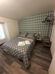 een slaapkamer met een bed met een zwart-wit dekbed bij Gîte La p'tite Maine in La Boissière-de-Montaigu