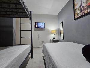 a bedroom with two bunk beds and a tv at Departamento CEFIRO 5 min de la playa in Mazatlán