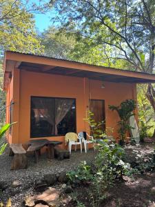 una pequeña casa naranja con una mesa de picnic delante de ella en Aldos place, en Playa Negra
