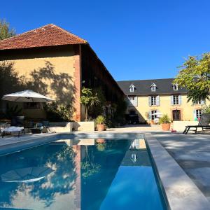 a swimming pool in front of a building at Maison de Haouret in Libaros