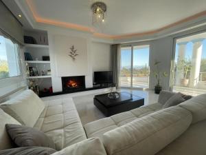 un soggiorno con divano bianco e camino di Olgas Luxury Villa, Corfu Greece a Evropoúloi