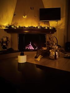 a living room with a fireplace with christmas lights at Cozy Apartment in Volos