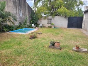 un patio trasero con una piscina en el césped en La Llera 2 en Baradero
