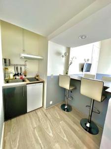 - une cuisine avec 2 chaises et une table dans l'établissement Appartement au bord des berges + parking, à Toulouse