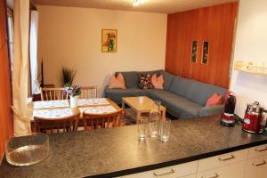 eine Küche und ein Wohnzimmer mit einem Sofa und einem Tisch in der Unterkunft Chalet Schwendihus - CharmingStay in Flumserberg