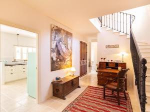een woonkamer met een bureau en een trap bij Casa La Fuente in Albuñuelas