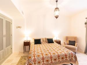 ein Schlafzimmer mit einem Bett und zwei Stühlen in der Unterkunft Casa La Fuente in Albuñuelas + 32 Fotos