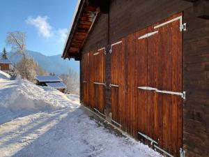 um celeiro de madeira com neve no chão em Chalet Sträba em Bellwald