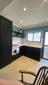 a kitchen with black cabinets and a sink and a window at T&L Apartments Germasogia in Limassol