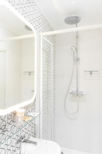 a white bathroom with a shower and a sink at La maison d'Yport in Yport