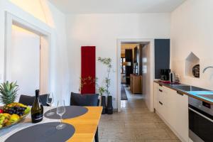 una cocina con una mesa con copas de vino. en BARONHAUS Aparthotel & Suites, en Passau