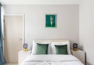 a bedroom with a white bed with green pillows at The Brixton residence in London
