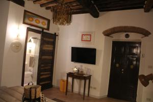 a living room with a flat screen tv and a door at La Porta sui Monti di Luna in Carrara